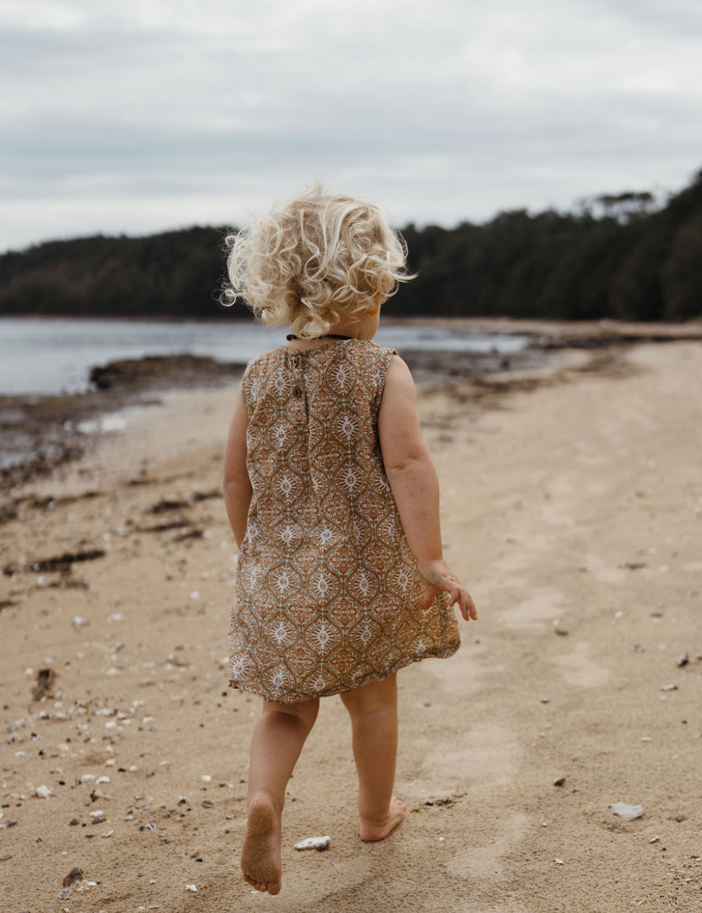 
                  
                    girl running on beach in fogo straight dress in retro funk print
                  
                