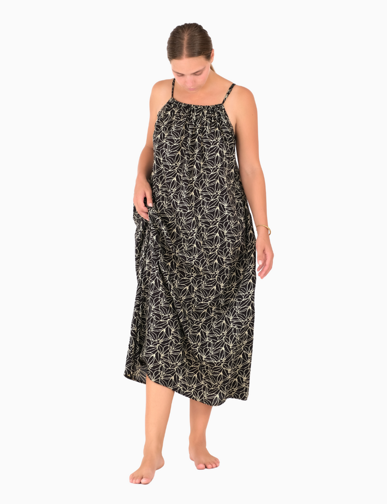 
                  
                    woman dressed in dark patterned gomera maxi dress in dark plum print in front of white background
                  
                