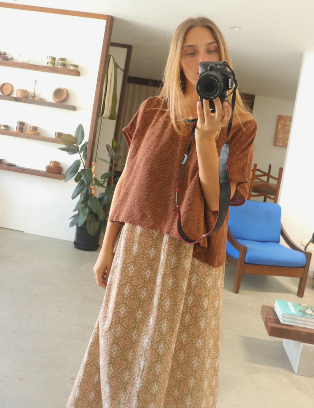 
                  
                    woman dressed in light patterned maxi dress in retro funk print with corvo loose fit top in net rust in front of mirror in Byron Bay
                  
                