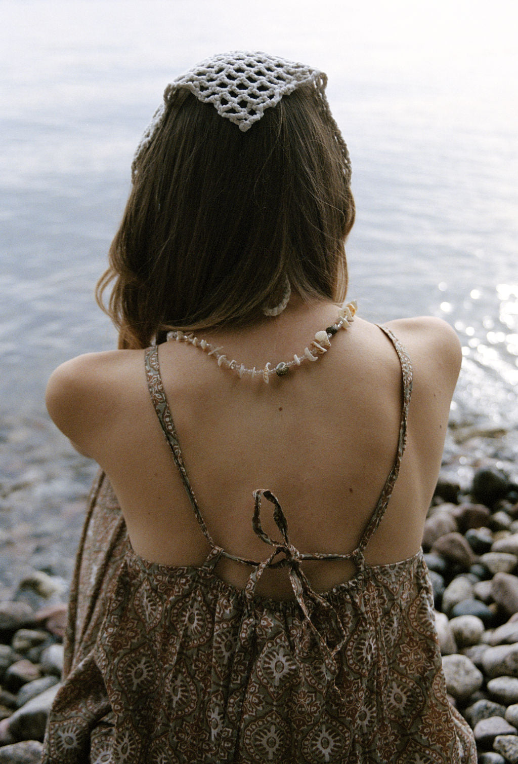 women dressed in beige patterned mini dress in front of ocean