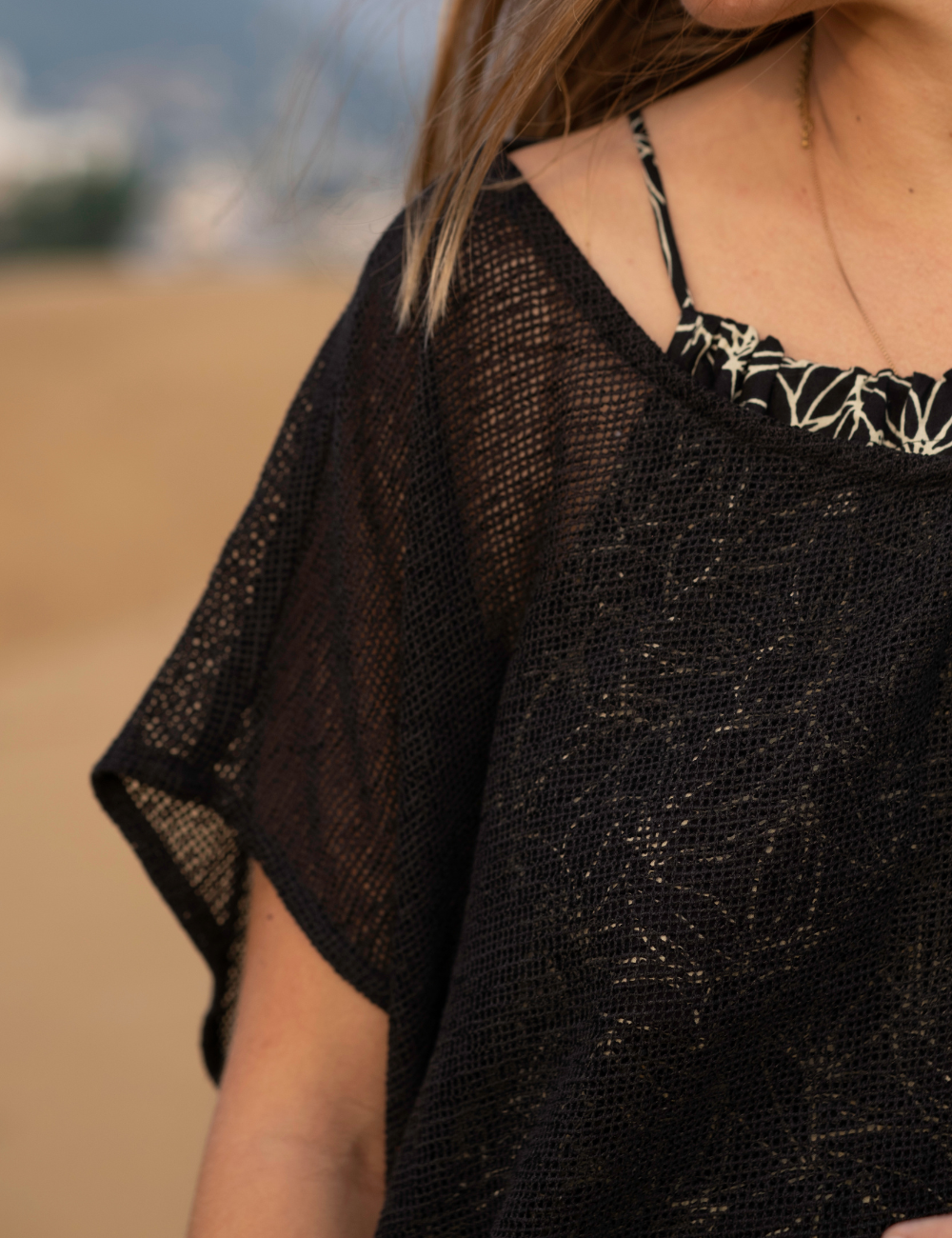 
                  
                    woman dressed in dark patterned strap dress with oversized net charcoal top in Indian desert
                  
                