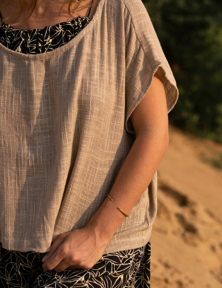 
                  
                    woman dressed in dark patterned mini dress with oversized taupe coloured top in Indian desert
                  
                