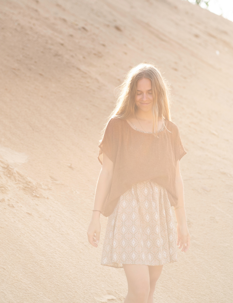 
                  
                    woman dressed in retro block printed mini dress with oversized net rust top in Indian desert
                  
                