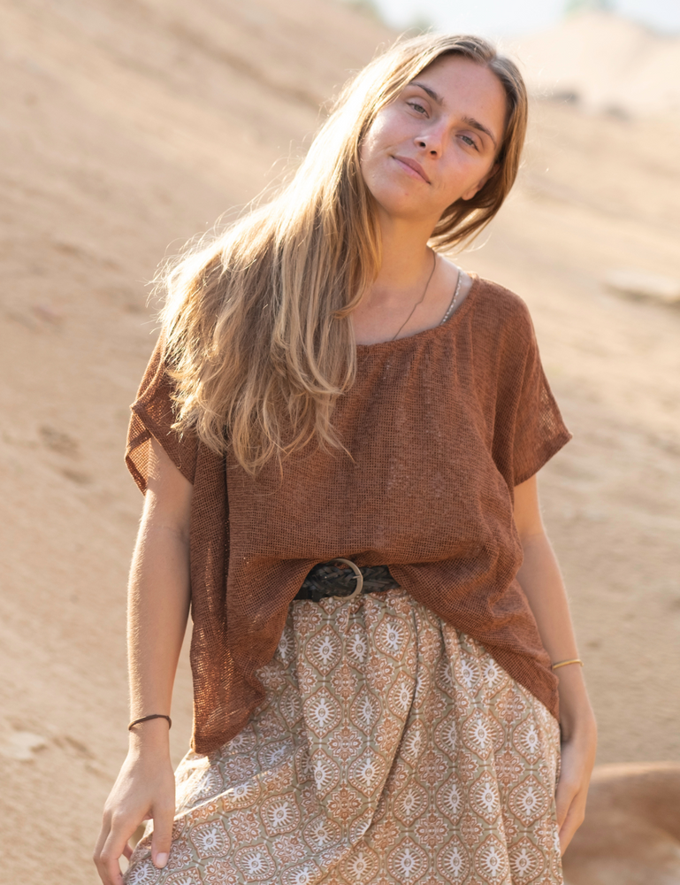 woman dressed in retro block printed mini dress with oversized net rust top in Indian desert