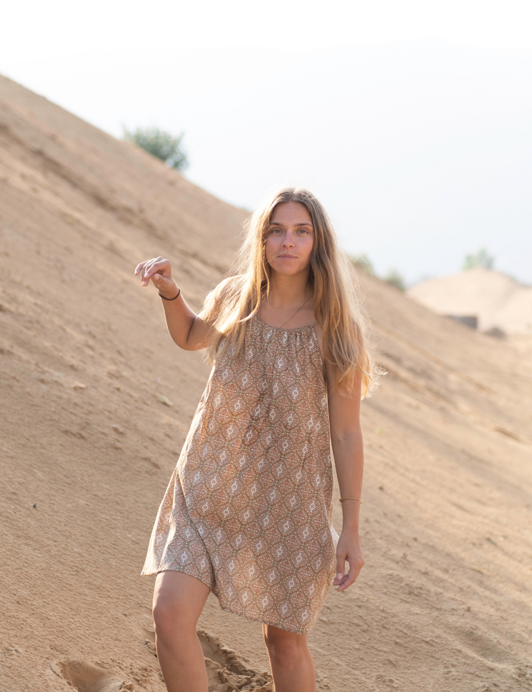 woman dressed in light coloured retro patterned mini dress in Indian desert