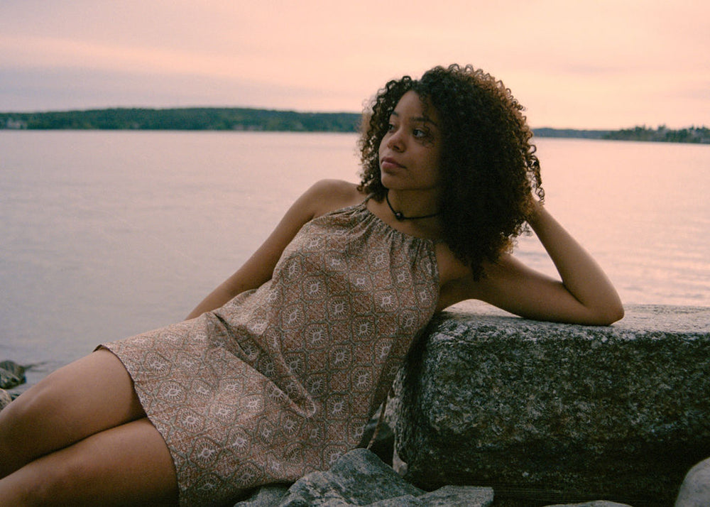 
                  
                    women dressed in beige patterned mini dress in front of ocean
                  
                