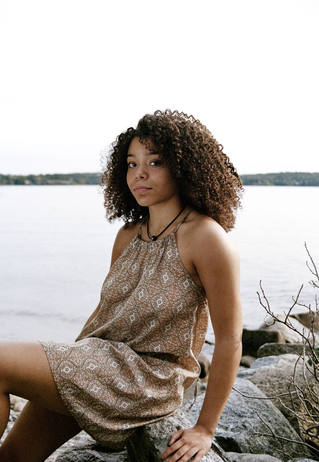 
                  
                    women dressed in beige patterned mini dress in front of ocean
                  
                