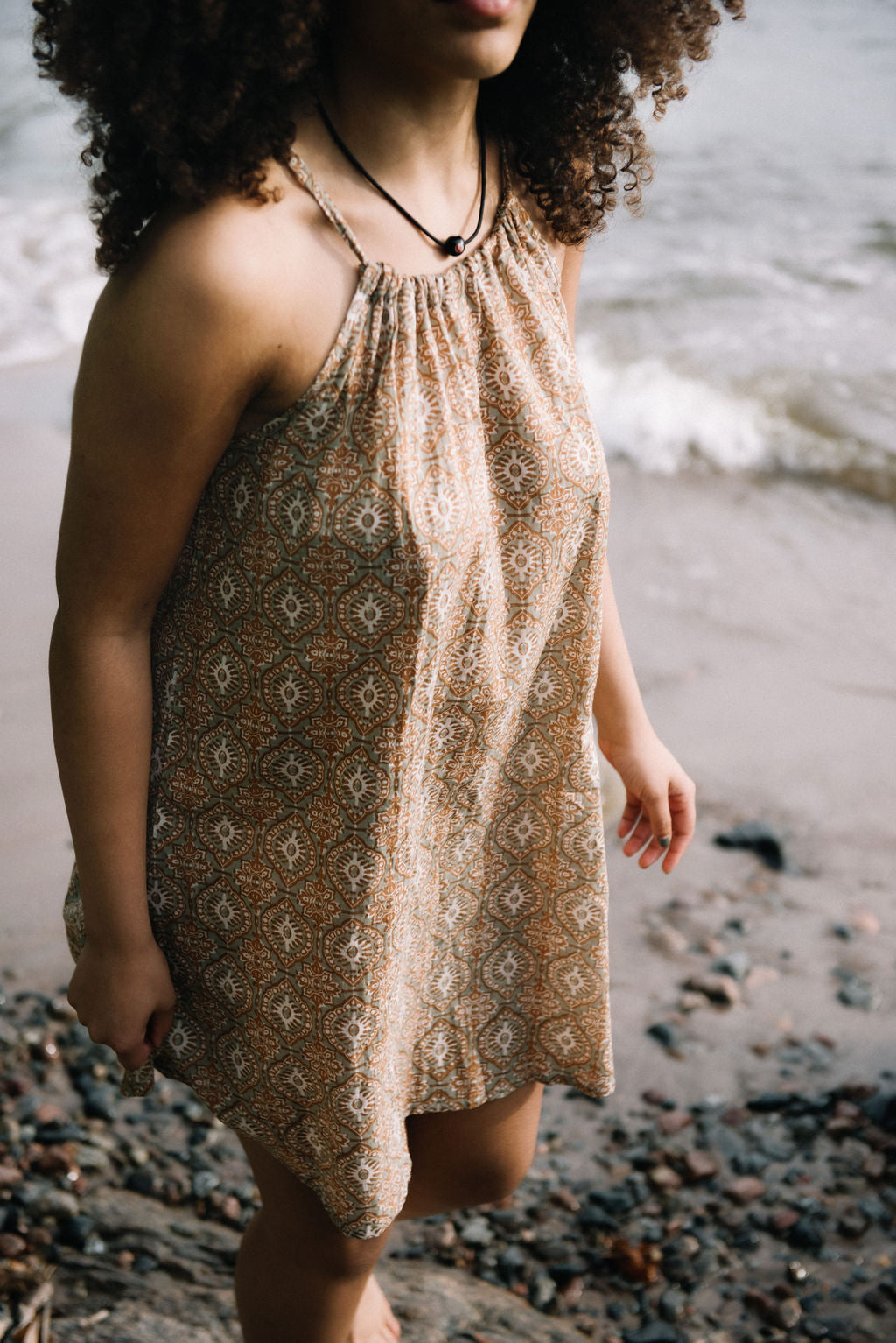 
                  
                    women dressed in beige patterned mini dress in front of ocean
                  
                