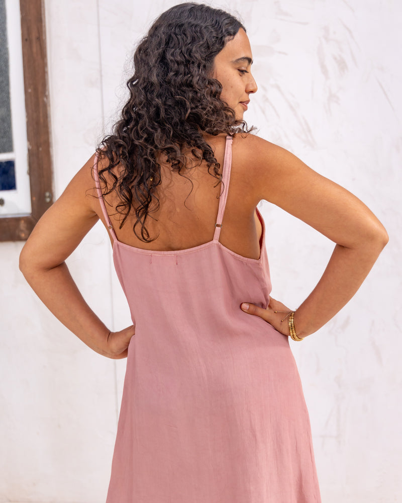 
                  
                    woman dressed in maio mini slip in orange peel fibre in dirty rose pink standing in front of a white wall
                  
                