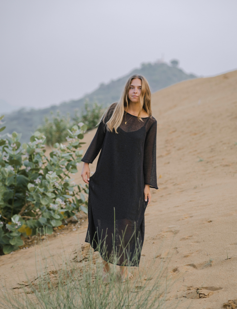 
                  
                    woman dressed in oversized maxi dress in net charcoal in Indian desert with plant in background
                  
                
