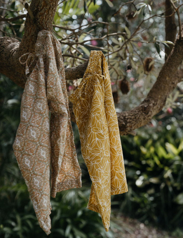 
                  
                    Indian retro block printed pants in retro funk and mustard seed print hanging on tree branch
                  
                