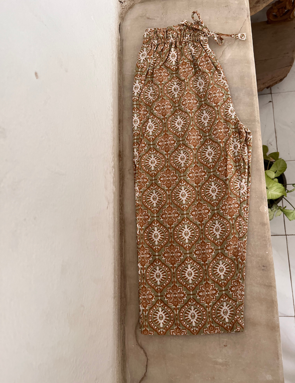 
                  
                    flat lay photo of indian block printed pants in retro funk print on concrete shelf
                  
                